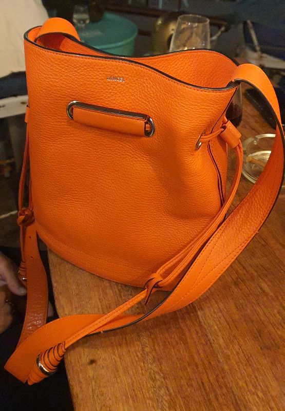 Sac à main seau Lancel modèle Huit en cuir orange contemporain avec accessoires dorés