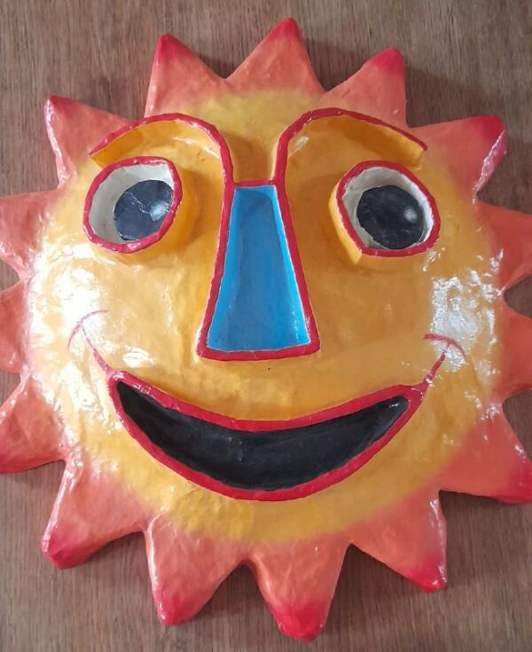 Sculpture en forme de soleil en papier mâché, années 1960-1970, visage souriant avec des yeux ronds et une bouche ouverte, suggérant une expression joyeuse